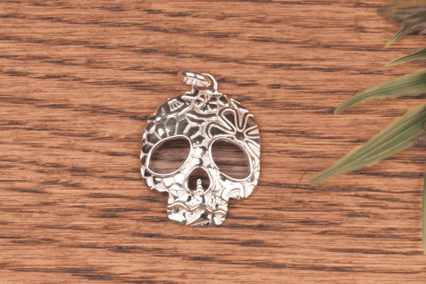 Dije de plata de calavera de azúcar.