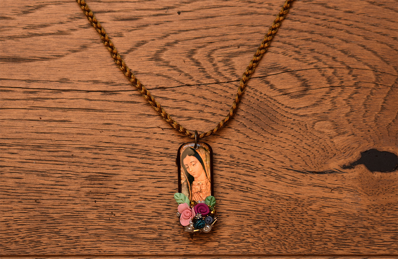 Collar de la Virgen de Guadalupe con flores y piedras.